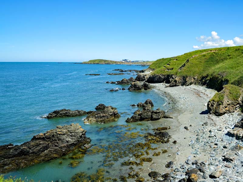 Photo looking along the coast of Anglesey on a clear and sunny day.